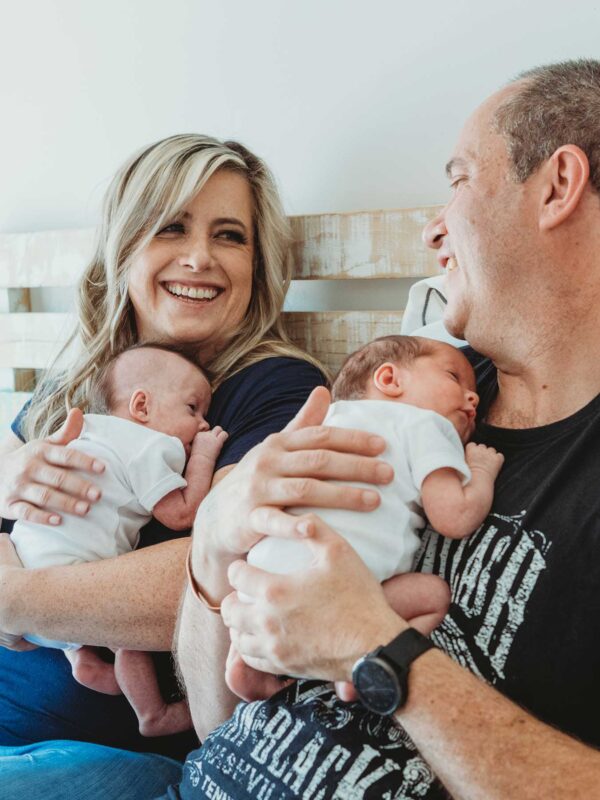 Parents holding twin newborn babies