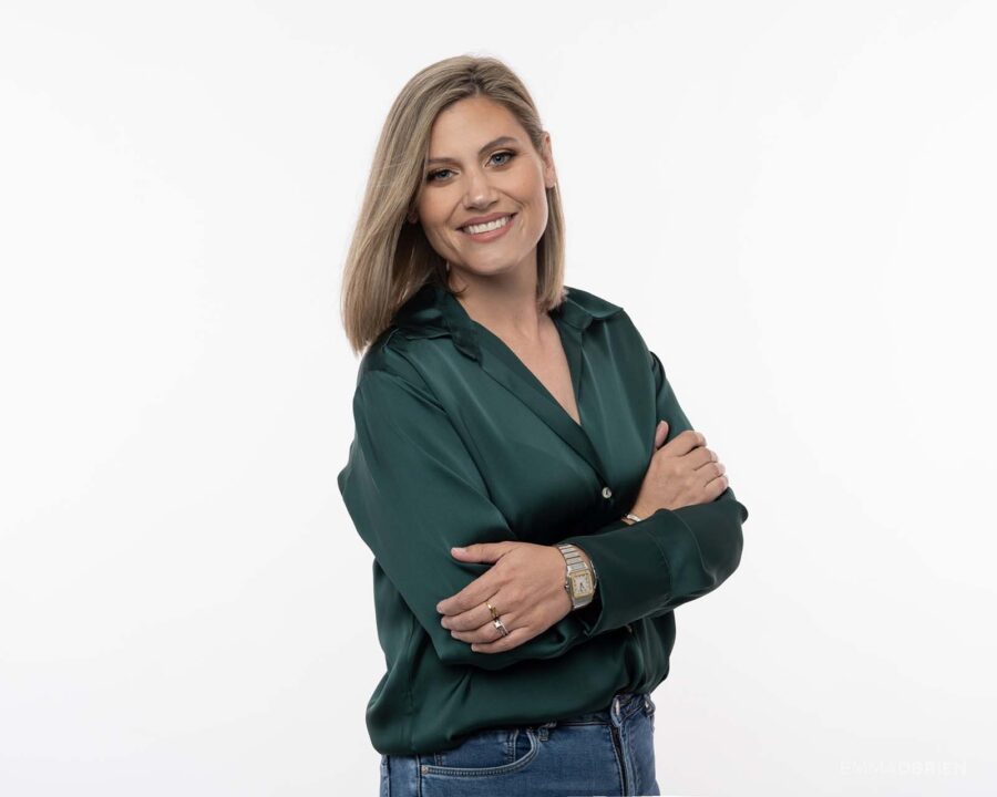 woman in a green blouse photographed against a white studio backdrop