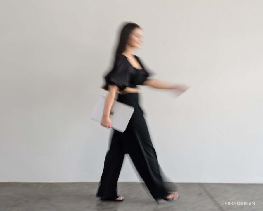woman walking against a white wall